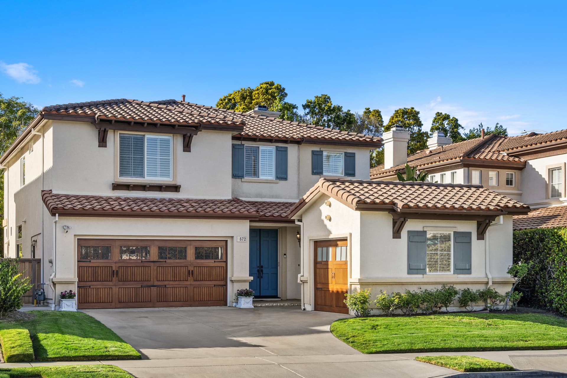 Matterport 3D tour of a two-story Spanish-style home with tile roof and wood garage doors