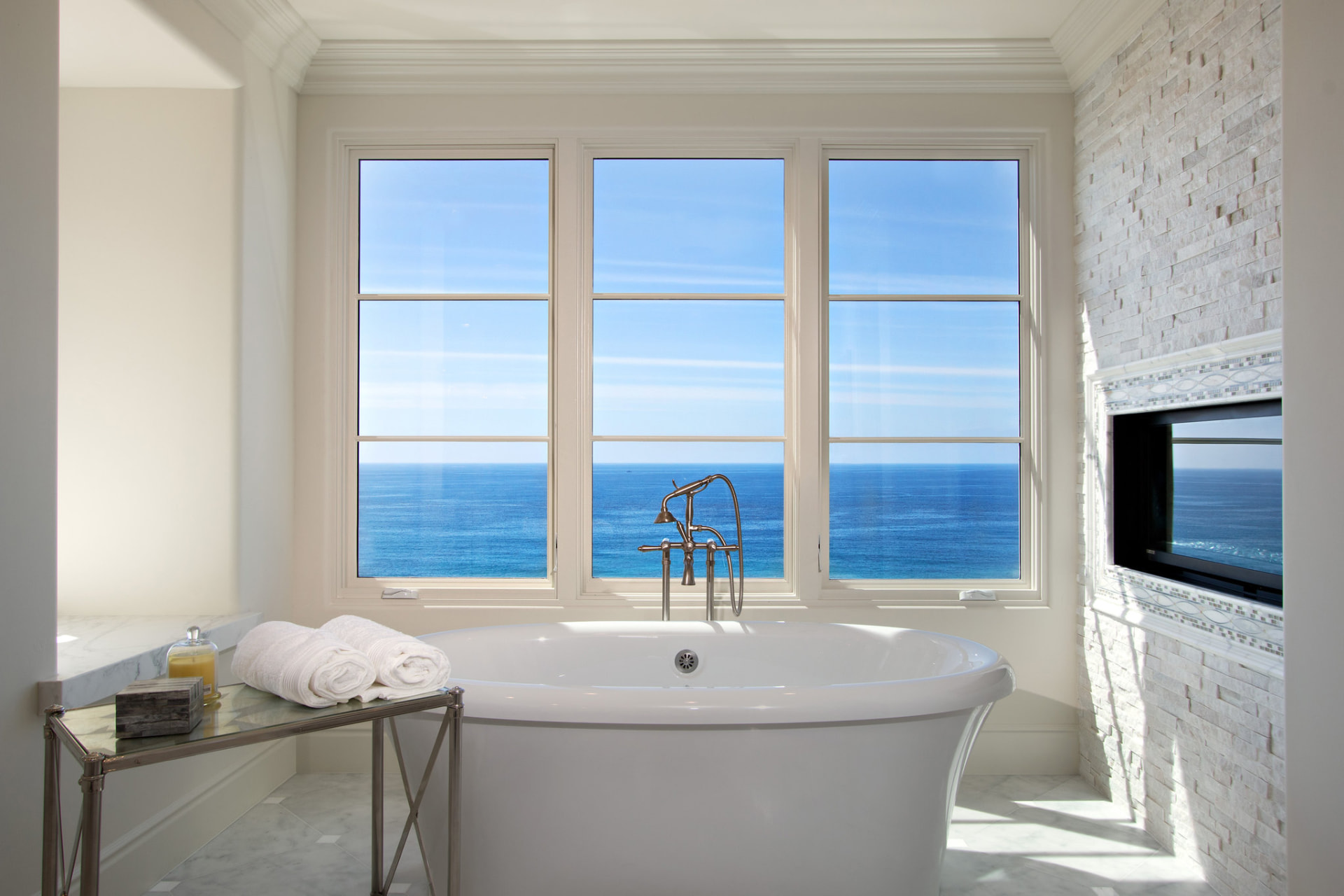Soaking tub in front of picture windows with ocean views
