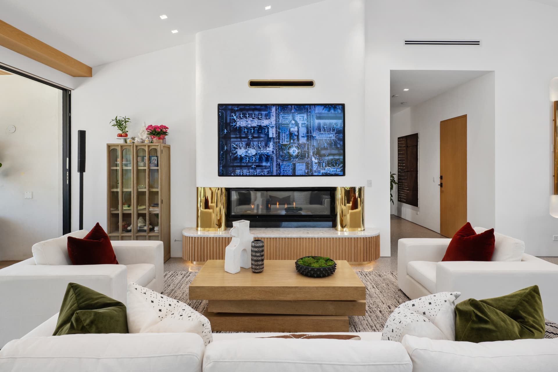 Bright white living room with a fireplace and flat-screen TV