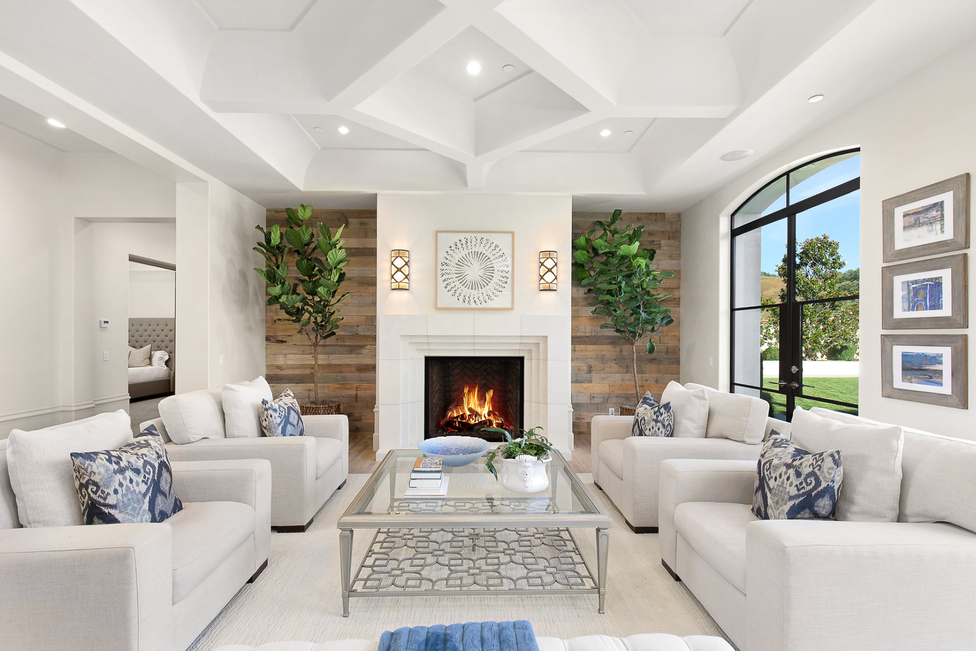 Living room with a coffered ceiling, fireplace and wood-paneled walls